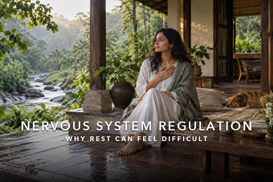 Woman resting beside a forest stream for nervous system regulation