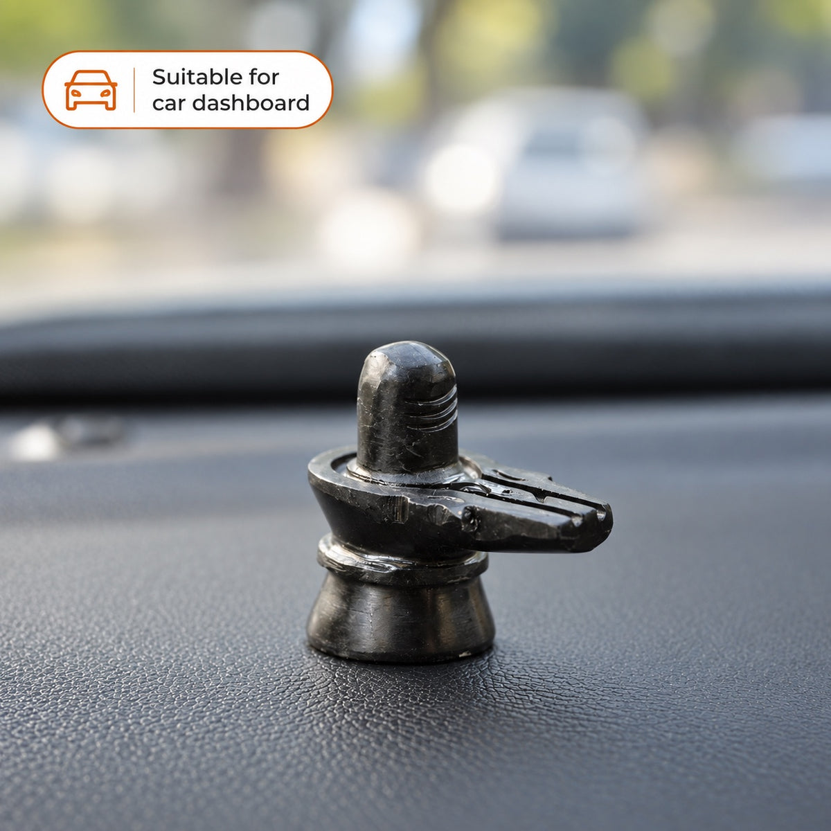 Black stone Shivling displayed on a car dashboard