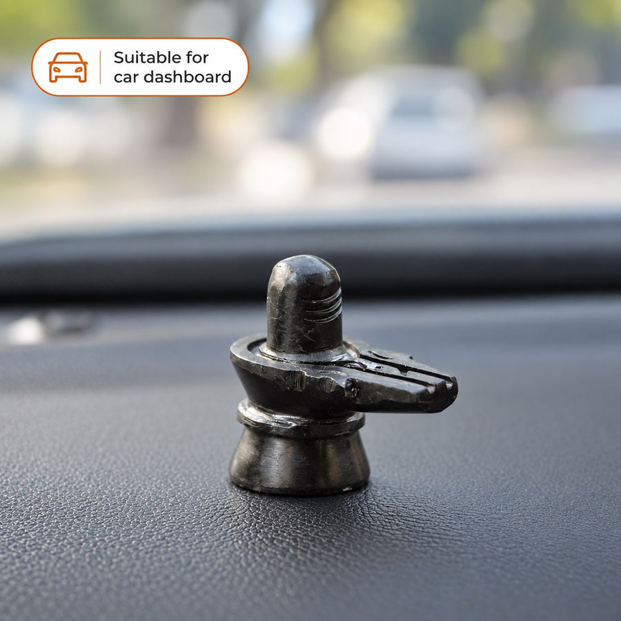 Black stone Shivling displayed on a car dashboard